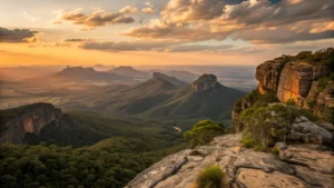 Vista panorâmica do pôr do sol no Morro do Pai Inácio, Chapada Diamantina, com vales verdejantes e formações rochosas sob céu alaranjado